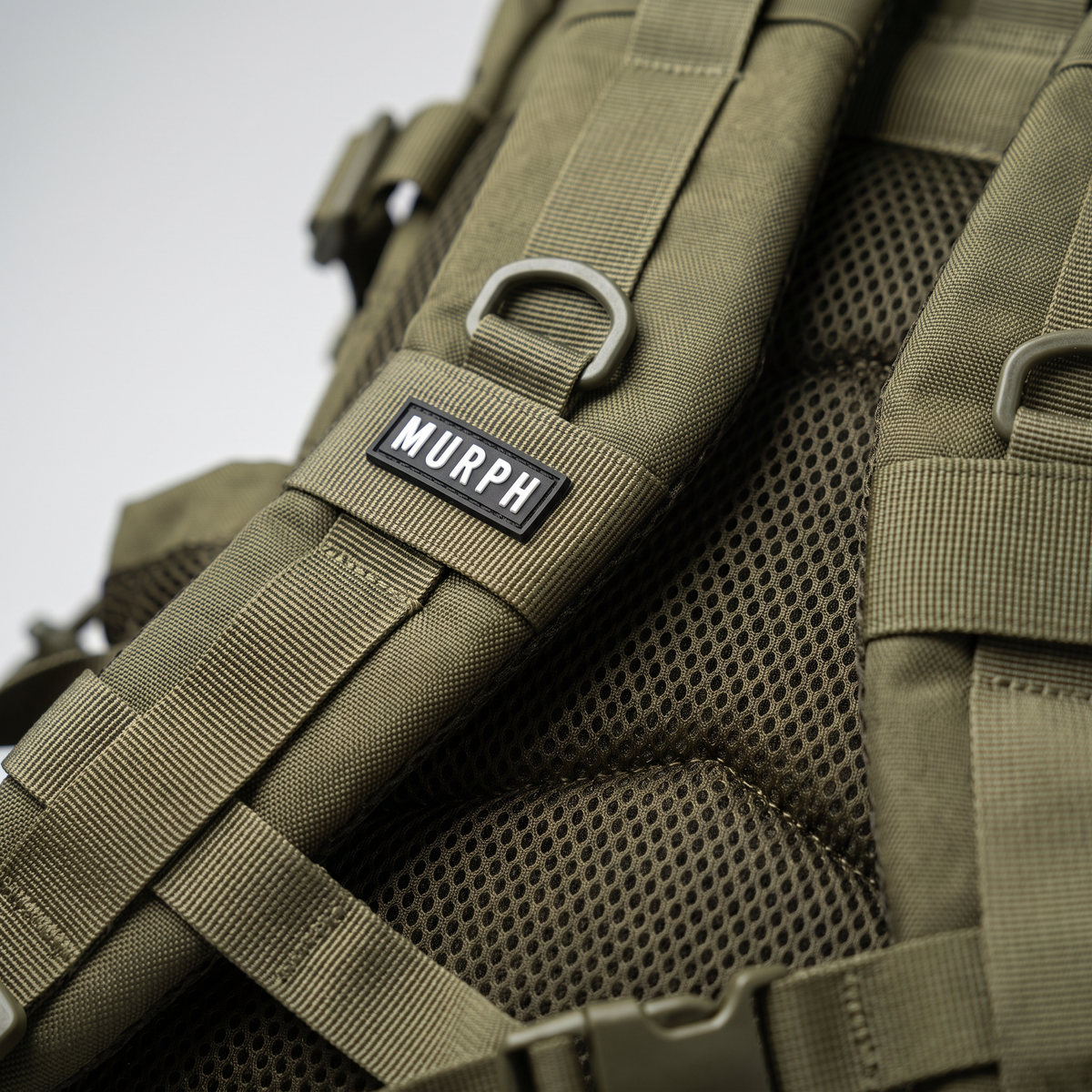Gros plan de la bretelle et du logo brodé du sac Murph Hero 25L kaki