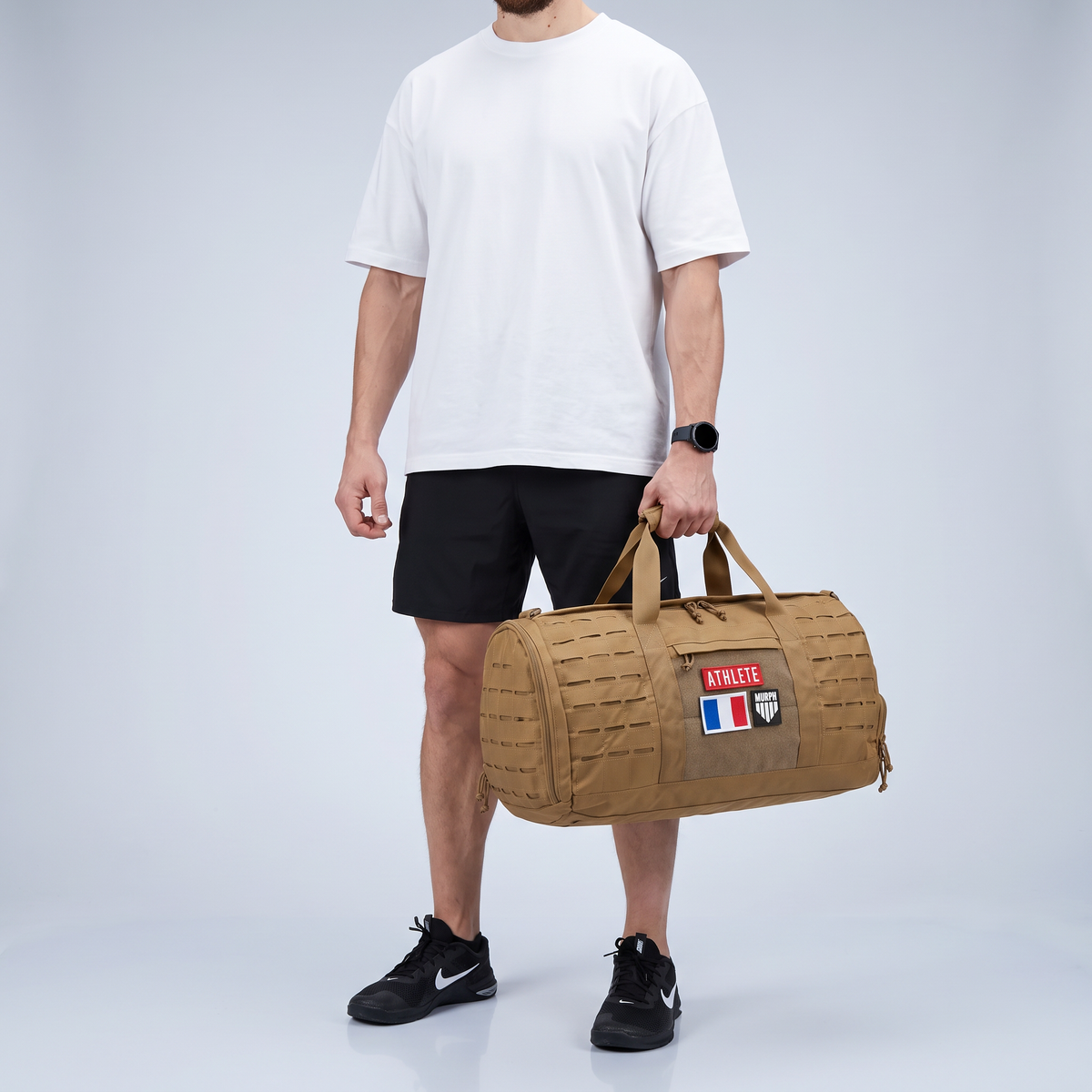 Athlete portant le sac polochon tactique Murph marron a la main