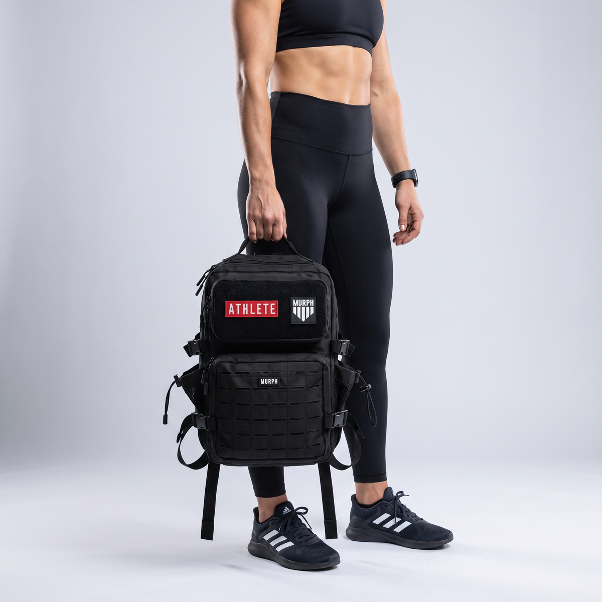 Sac à dos tactique Murph Hero 25L noir porté à la main par une femme